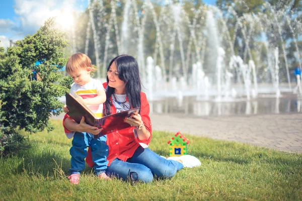 Bela mãe e criança menina ao ar livre mãe feliz mostrando-lhe — Fotografia de Stock