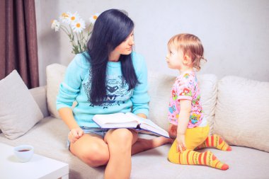 Güzel bir anne ve sevimli kızı oturmuş portre 