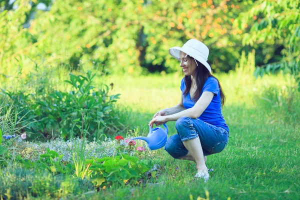 Счастливая зрелая женщина заботится о своих цветах в саду . — стоковое фото