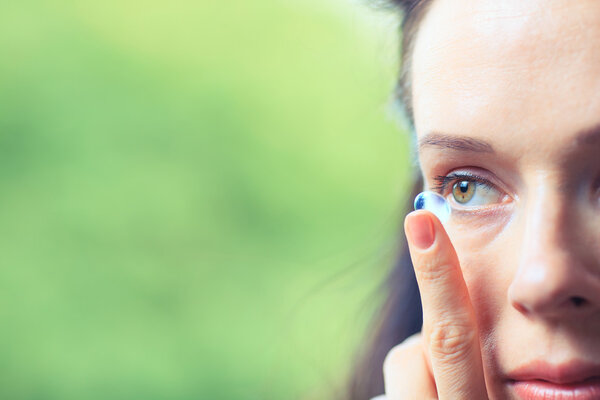 Close up of a woman putting contact lens in her eye