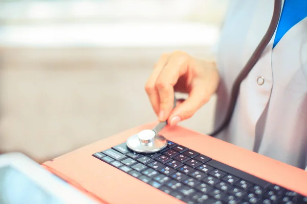 Компьютерный врач осматривает ноутбук на белом фоне — стоковое фото