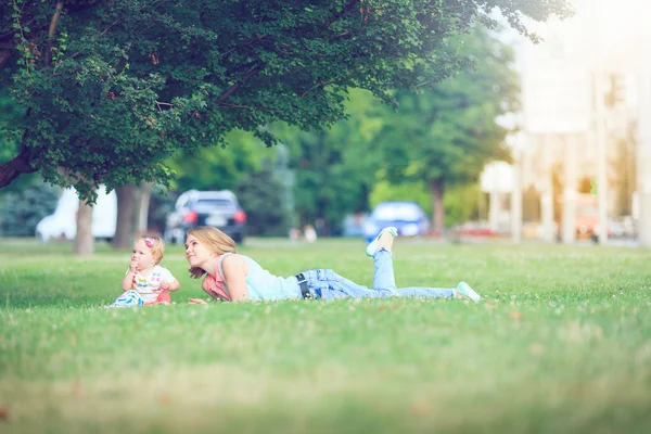 Gelukkig gezin van drie liggen in het gras . — Stockfoto