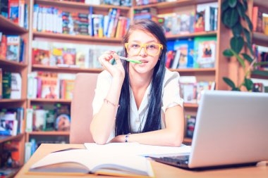 Kütüphanede kitap okuma gözlüklü kız öğrenci