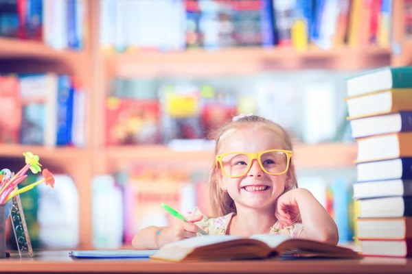 Portret van een schattig babymeisje met bril op tafel — Stockfoto