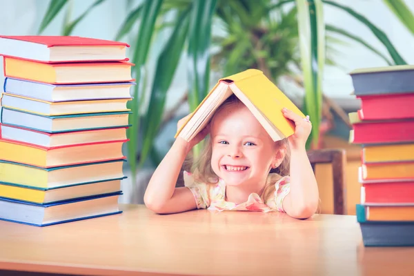 Portret van een schattig babymeisje met bril op tafel — Stockfoto