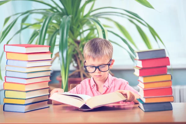 Schooljong geitje studeren in de bibliotheek, kind schrijven boek van de kopie papier in — Stockfoto