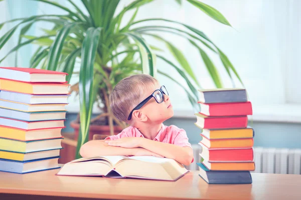 Schooljong geitje studeren in de bibliotheek, kind schrijven boek van de kopie papier in — Stockfoto