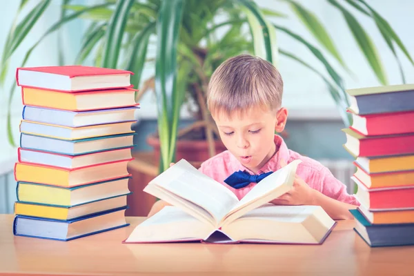 Schooljong geitje studeren in de bibliotheek, kind schrijven boek van de kopie papier in — Stockfoto