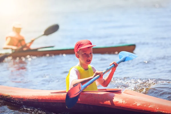 Junge Leute paddeln auf einem Fluss in schöner Natur. — Stockfoto