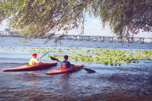 Jongeren zijn kajakken op een rivier in de prachtige natuur. — Stockfoto