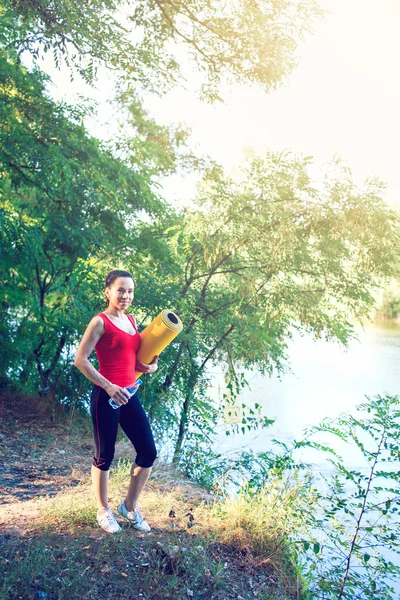 Adolescente haciendo yoga y relajándose al sentarse en una hierba en un parque — Foto de Stock