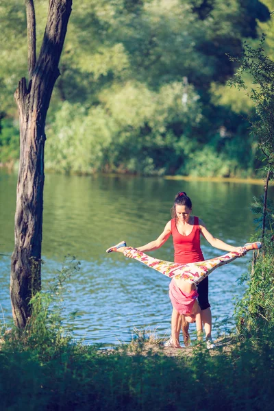 Aile egzersiz - anne ve kızı plajda egzersizleri yapıyor. — Stok fotoğraf