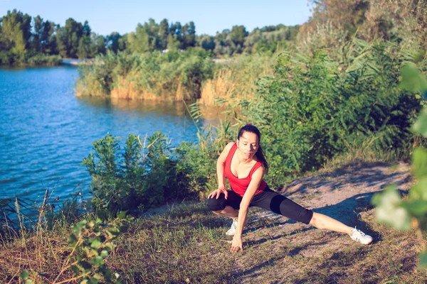 Adolescent faire du yoga et se détendre en s'asseyant dans une herbe dans un parc — Photo