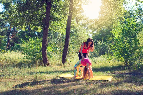 Familientraining - Mutter und Tochter machen Übungen am Strand. — Stockfoto