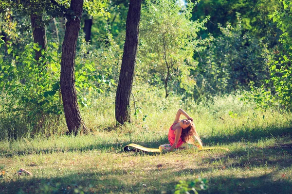 Remaja melakukan yoga dan bersantai dengan duduk di rumput di taman — Stok Foto