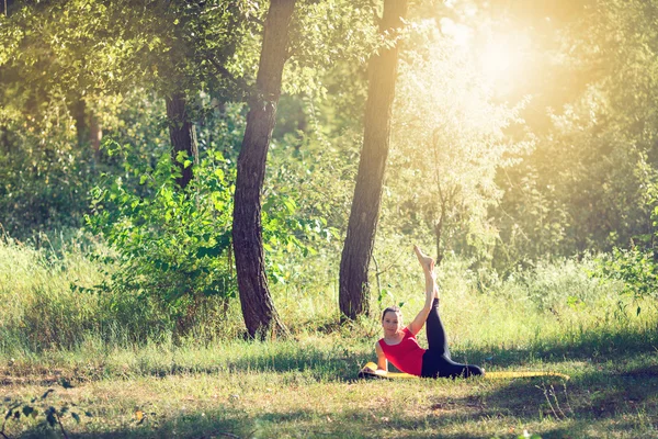 Adolescent faire du yoga et se détendre en s'asseyant dans une herbe dans un parc — Photo