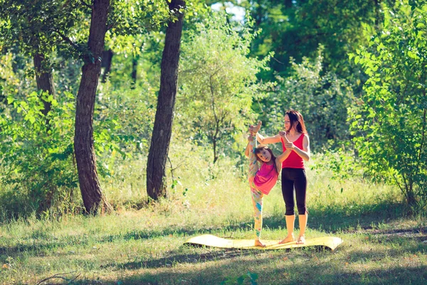 Treino familiar - mãe e filha fazendo exercícios na praia . — Fotografia de Stock