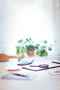 Bilgisayarı ve ahşap masasında akıllı telefonu olan bir ofis.