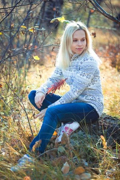 Junge Frau spielt an einem Herbsttag mit Laubsündenpark. — Stockfoto