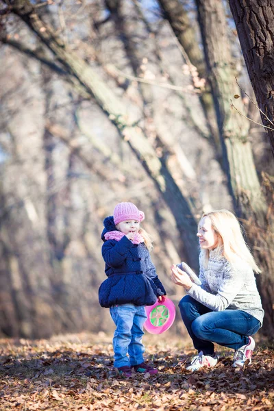 Jonge moeder en haar peuter meisje in herfst velden — Stockfoto