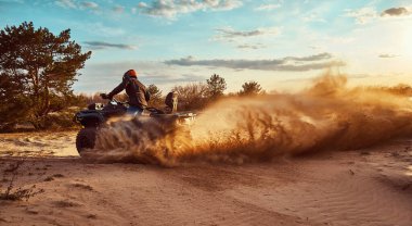 Kum tepeleri içinde Atv sürme Genç kum bir dönüş yapma