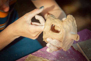 Çocuklar kille oynuyorlar ve boyalarla çiziyorlar..