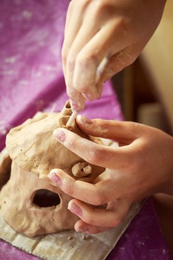Çocuklar kille oynuyorlar ve boyalarla çiziyorlar..