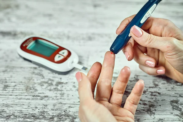 Zbliżenie Kobiecej Ręki Sprawdzającej Poziom Cukru Krwi Pomocą Glukometru — Zdjęcie stockowe