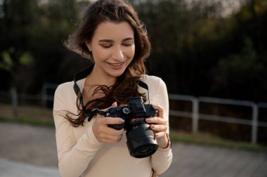 Dışarıdaki kameraya bakarken gülümseyen genç bir kadın..