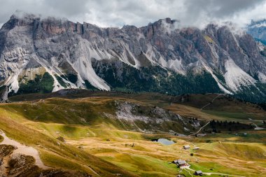 Dolomitlerin dramatik zirveleri yemyeşil alp çayırlarının üzerinde yükseliyor. Küçük dağ gölleri ve küçük dağ suları ile benekli.