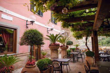 İtalya 'nın Tivoli şehrinde yemyeşil otlaklar, saksılar ve akşam yemeği için hazırlanan masalarla birlikte açık bir kafe.