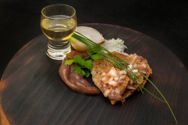 Otantik bir aperatifin üst görüntüsü: havyarlı çavdar ekmeği, taze soğan ve maydanoz. Dokulu ahşap ve derin gölgeler ev konforu ve geleneksel mutfak ortamı yaratır..