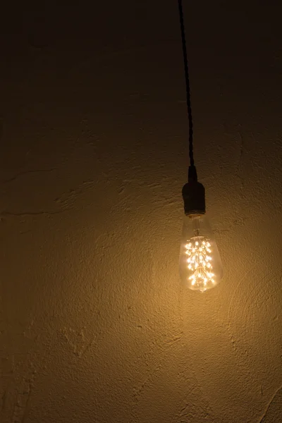 Glühbirne hängt an Betonwand — Stockfoto