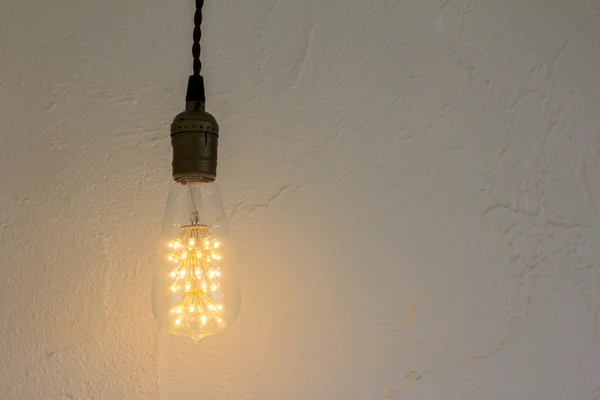 Glühbirne hängt an weißer Wand — Stockfoto