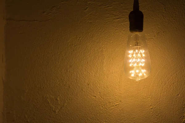 Glühbirne hängt an Betonwand — Stockfoto