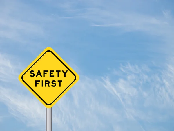 Sformułowanie "bezpieczeństwa pierwszy" na żółty znak na niebie — Zdjęcie stockowe