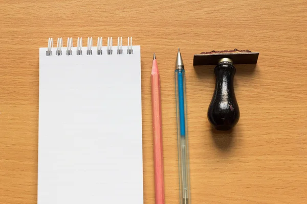 メモ用紙、鉛筆、ペン、木製のテーブルの上のゴム印 — ストック写真