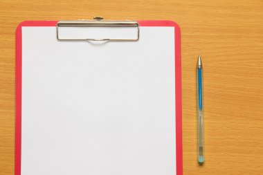 Kırmızı dosya ve ahşap masa üzerinde mavi kalem kağıt