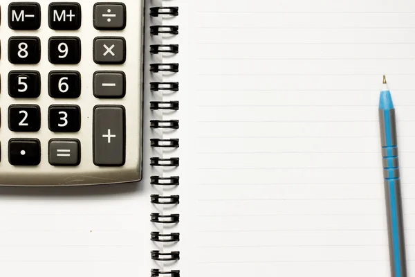 Niebieskie pióro i Kalkulator umieszczone na tle białej księgi — Zdjęcie stockowe