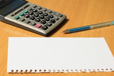 Mavi Kalem, hesap makinesi ve ahşap masa arka plan üzerinde beyaz kağıt