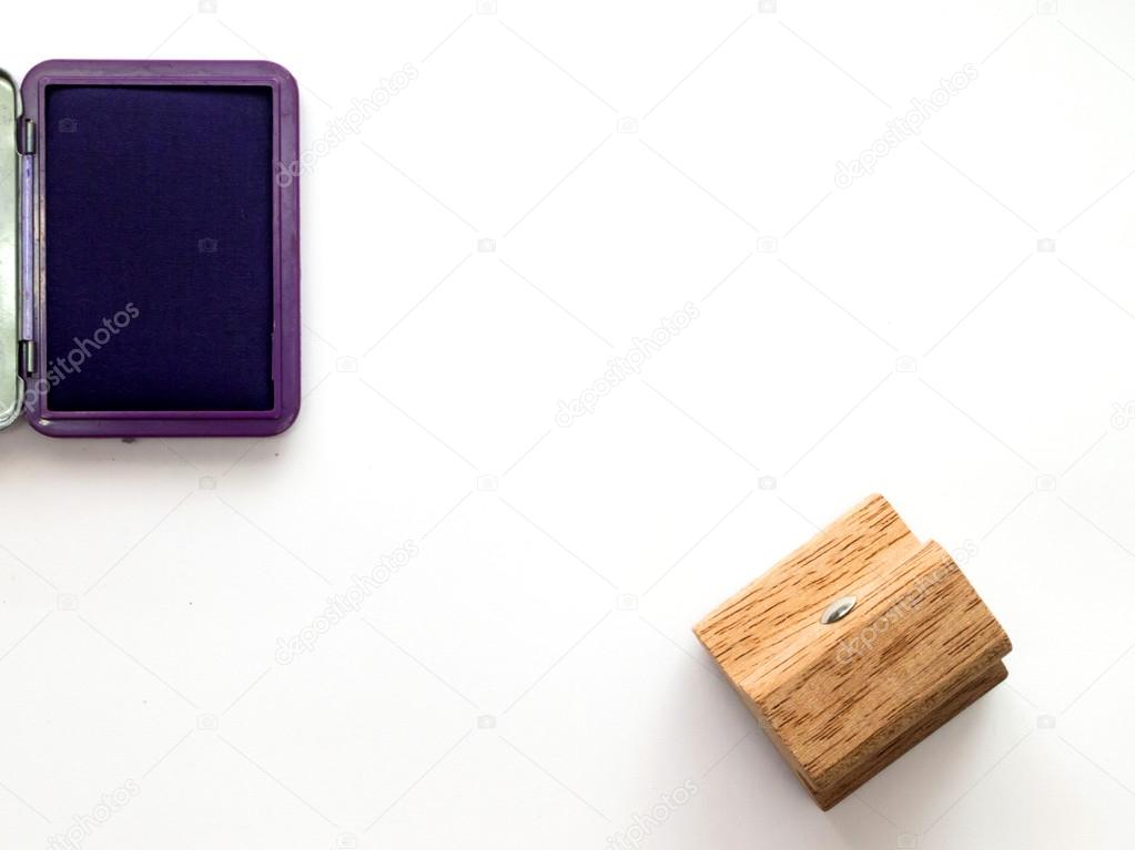 Wooden rubber stamp with violet ink tray on white background