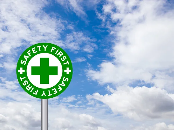 Ordalydelsen "säkerhet första" i grön trafik tecken på blå himmel backgro — Stockfoto