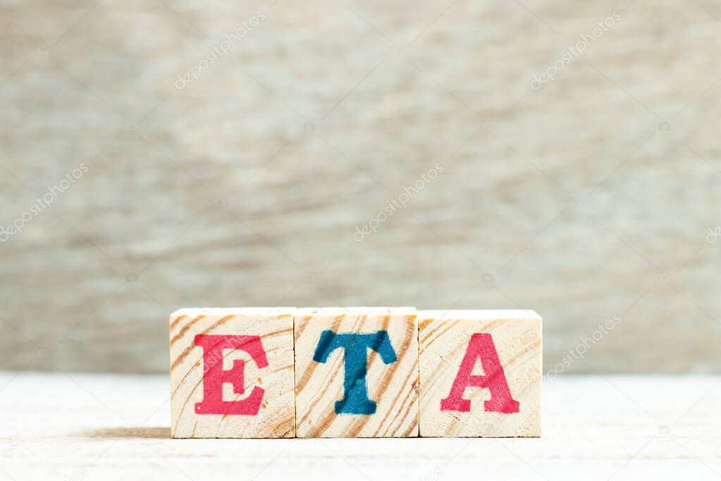 Alphabet letter in word ETA (abbreviation of estimated time of arrival) on wood background