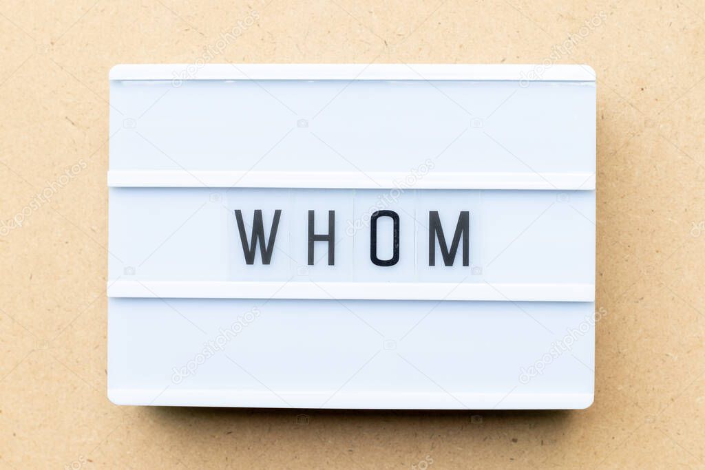 White lightbox with word whom on wood background