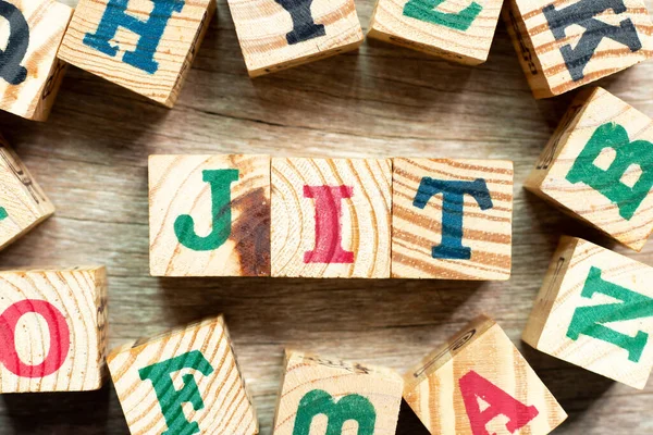 stock image Alphabet letter block in word JIT (abbreviation of just in time) with another on wood background