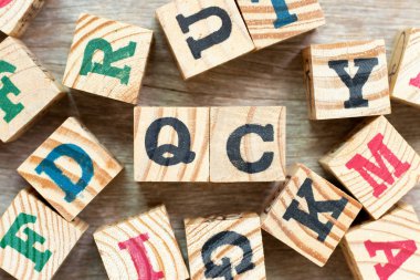 Kelime QC (Kalite Kontrolünün kısaltılmışı) ile alfabe harf bloğu tahta zemin üzerinde başka bir