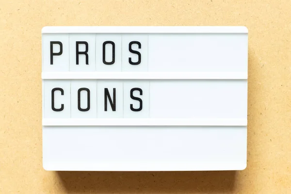 Lightbox with word  pros cons on wood background