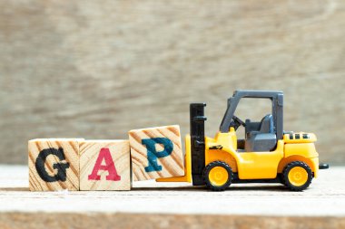 Oyuncak forklift harf bloğu P 'yi GAP (ahşap arkaplan üzerindeki iyi tarım uygulamasının kısaltması) tamamlamak için