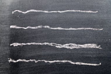 Siyah tahta zemin üzerinde dalgalı çizgi şeklinde beyaz tebeşirli el çizimi