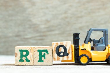 Oyuncak forklift harf bloğu Q 'yu tahta arkaplanda RFQ (tırnak için talep kısaltması) tamamlamak için tutar